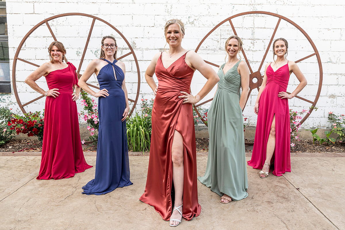 Five women dressed in coordinating bridesmaid attire, smiling and celebrating together, symbolizing friendship and joy for special occasions